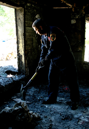 fire investigator digging through rubble